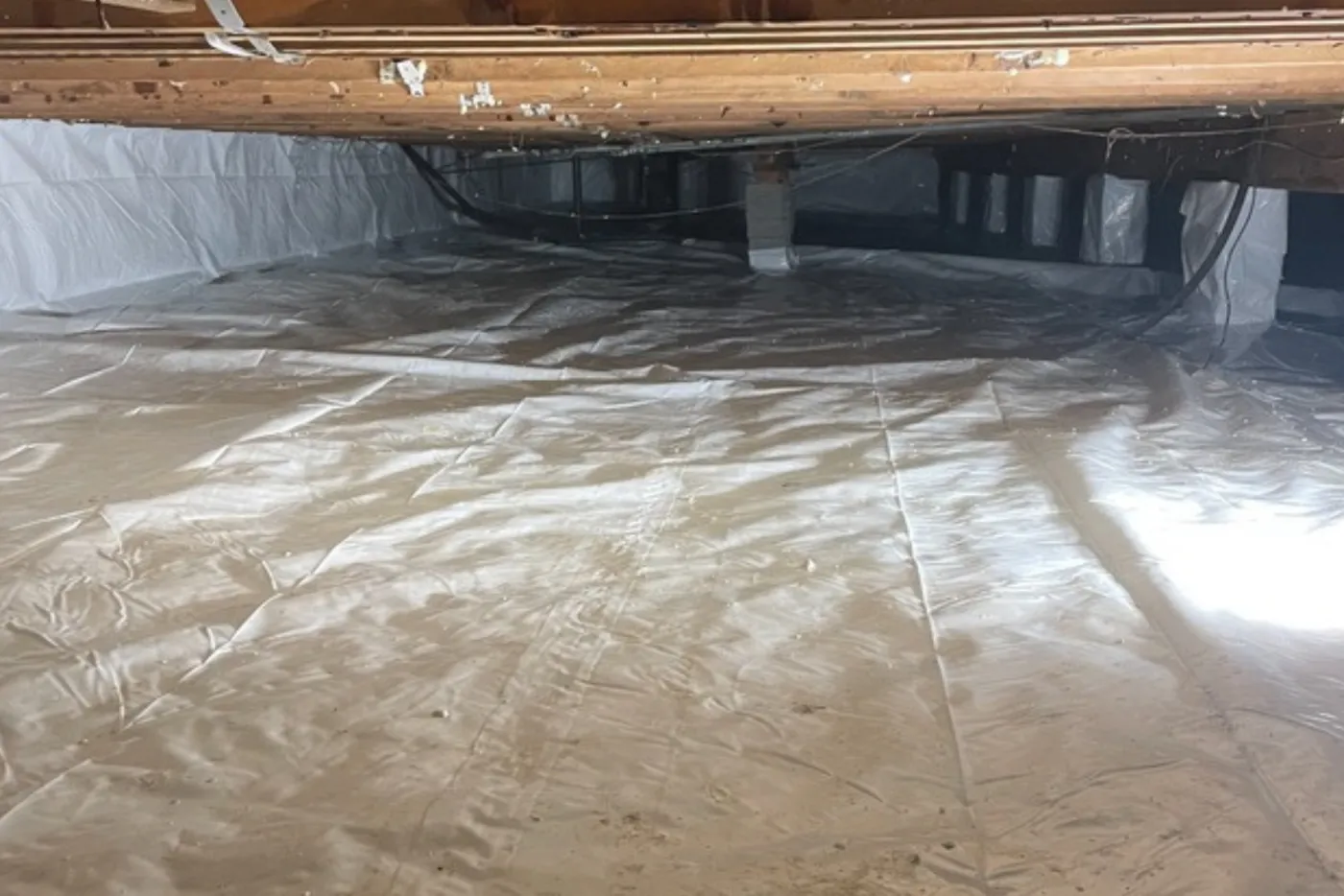An encapsulated crawl space, with the vapor barrier running to the far wall.