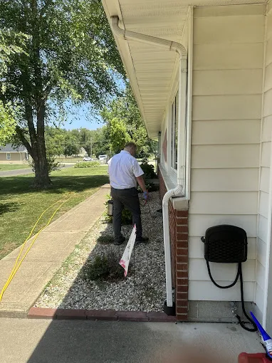 A Spot On technician treating along the foundation of a home.